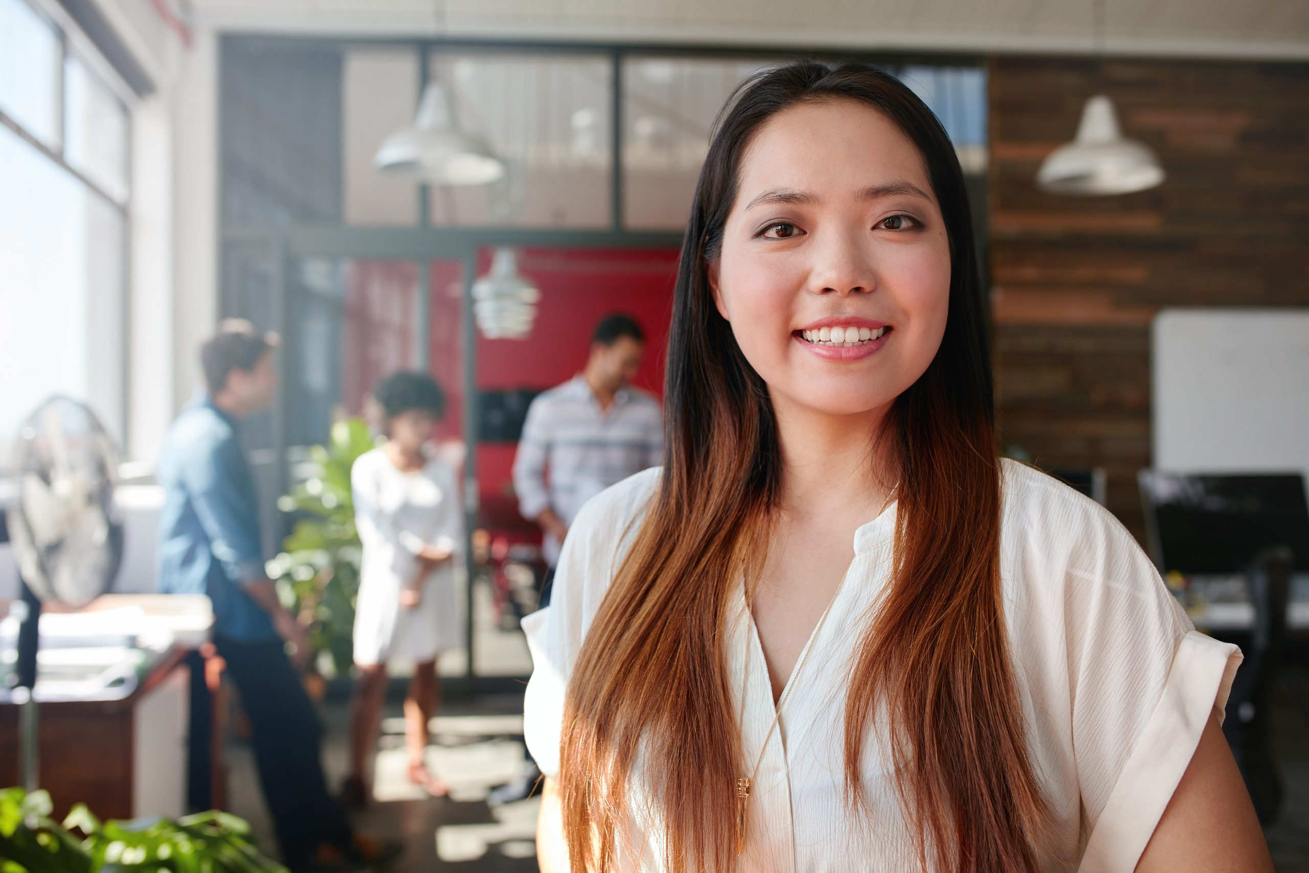 smiling-young-businesswoman-in-office-P7BUN7K-scaled.jpg